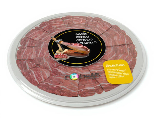 Bandeja circular de jamón ibérico cortado a cuchillo, envasado al vacío y presentada con etiqueta central negra y precinto de excelencia, sobre fondo blanco