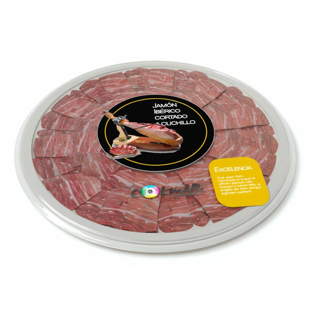 Bandeja circular de jamón ibérico cortado a cuchillo, envasado al vacío y presentada con etiqueta central negra y precinto de excelencia, sobre fondo blanco