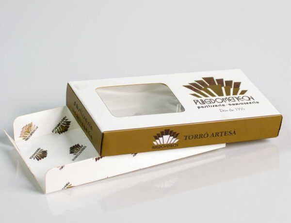 Caja de cartón blanca con detalles dorados para turrón artesano, con ventana transparente en la tapa y bandeja interior decorada, fotografiada sobre fondo blanco